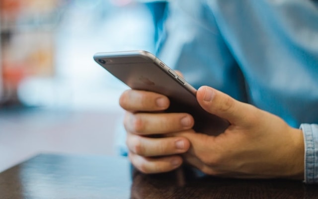 professional man holding iPhone mobile learning 