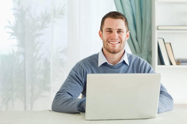 Happy smiling young businessman working in his home office