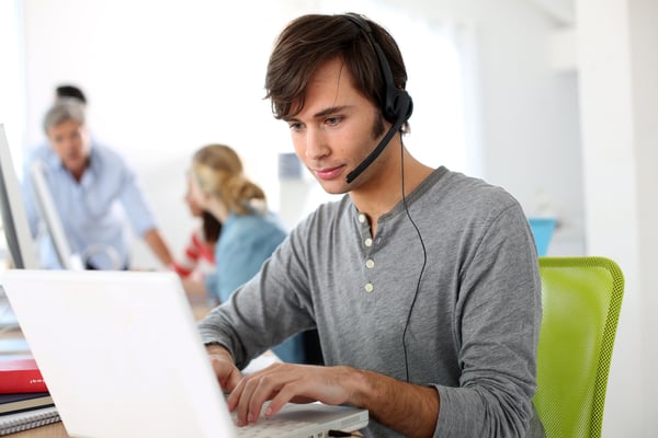 Employee with a headset working on a laptop