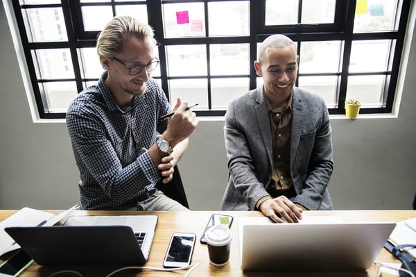 two men on computers using LMS software for leadership development